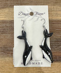 Black and white whale-shaped earrings on a card with 'Dayne Olson' branding.