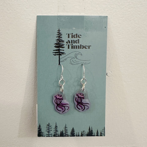Pair of earrings on a 'Tide and Timber' branded card with a nature-themed design.