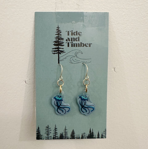 Earrings on a Tide and Timber branded card with a tree and wave design.