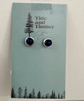 Pair of earrings on a 'Tide and Timber' branded card with a forest design.