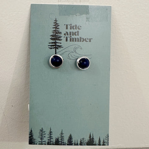 Pair of earrings on a 'Tide and Timber' branded card with a forest design.