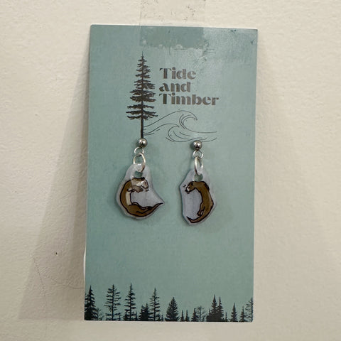 Pair of earrings on a 'Tide and Timber' branded card with a nature-themed design.