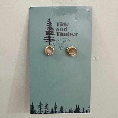 Pair of earrings on a 'Tide and Timber' branded card with a forest design.