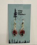 Pair of earrings on a 'Tide and Timber' branded card with a forest design.