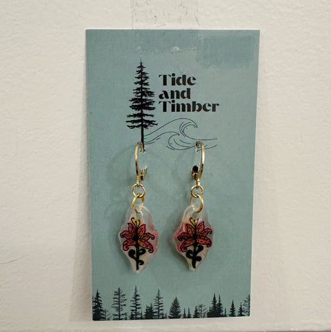 Pair of earrings on a 'Tide and Timber' branded card with a forest design.