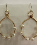 Gold hoop earrings with pearl beads on a white background