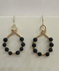 Pair of hoop earrings with black beads on a light background