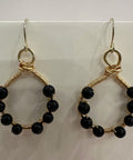 Pair of hoop earrings with black beads and gold wire on a white background