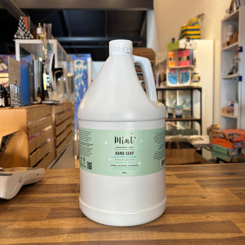 Large white container with a green label on a wooden surface, with a store interior in the background.