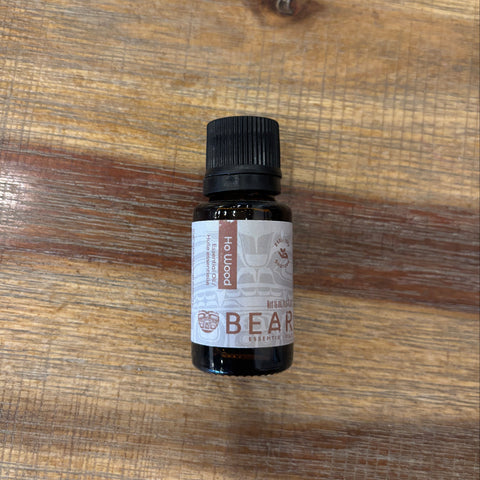 Bottle of Bear Ho Wood essential oil on a wooden surface