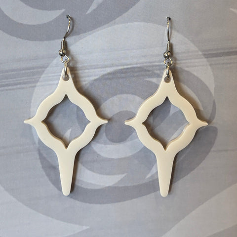 Coast Salish Art Earrings packaging with yarn and books in the background