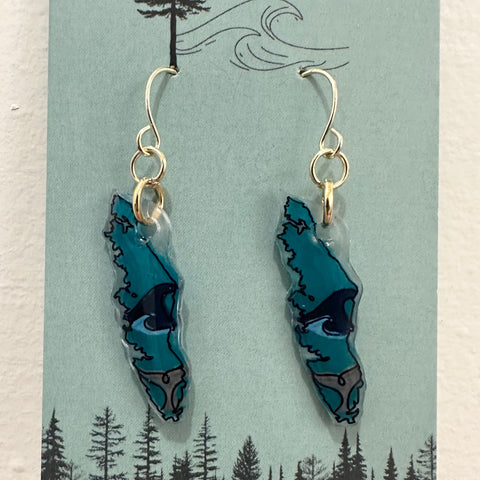 Teal wave-shaped earrings on a 'Tide and Timber' branded card with a forest design.