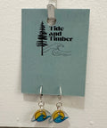 Earrings on a card with 'Tide and Timber' branding, hanging on a white surface.