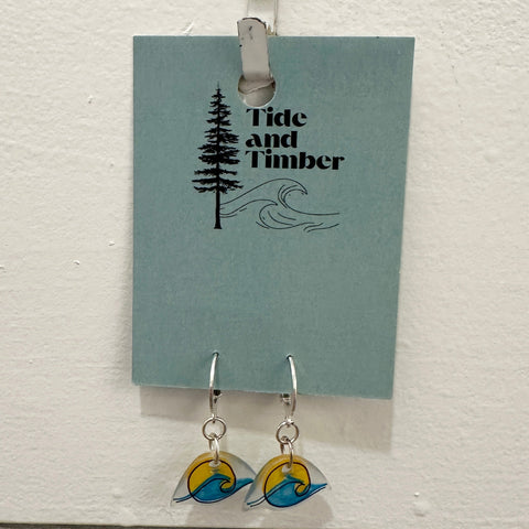 Earrings on a card with 'Tide and Timber' branding, hanging on a white surface.