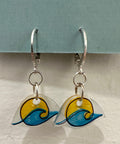 Pair of earrings with wave design on a gray background