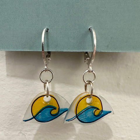 Pair of earrings with wave design on a gray background