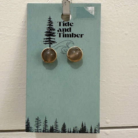 Pair of earrings on a 'Tide and Timber' branded card against a light background