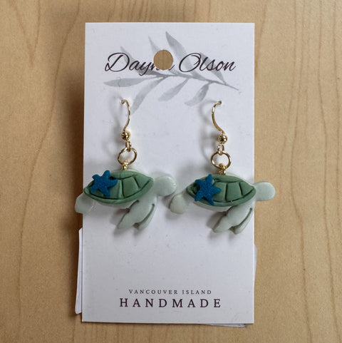 Turtle-shaped earrings on a 'Daya Olson' card with 'Vancouver Island Handmade' text.