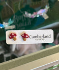 Card with mushroom earrings and 'Cumberland Creations' branding on a blurred background