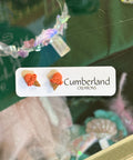 Product packaging with 'Cumberland' branding and decorative elements.