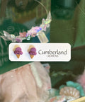 Earring set with 'Cumberland Creations' label on a green background