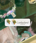 Close-up of a green bottle with a label featuring 'Cumberland' and images of plants.