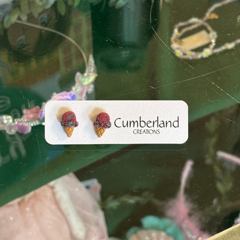 Earring display with 'Cumberland Creations' label in a store window.