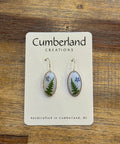 Pair of earrings on a 'Cumberland Eternities' card on a wooden surface