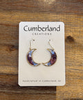 Crescent moon earrings on a Cumberland Creations card against a wooden background