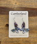 Earring on a card with 'Cumberland Creations' branding on a wooden surface