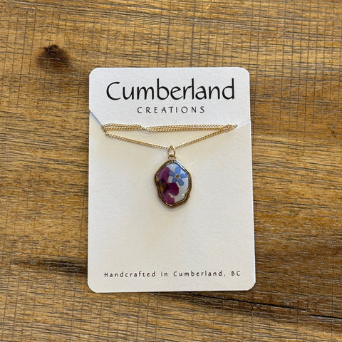 Necklace with a pendant on a Cumberland Creations card against a wooden background