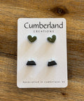 Pair of earrings on a 'Cumberland Creations' card on a wooden surface