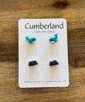 Set of earrings on a Cumberland Creations card on a wooden surface