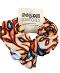 Colorful scrunchie with a brand tag on a wooden surface