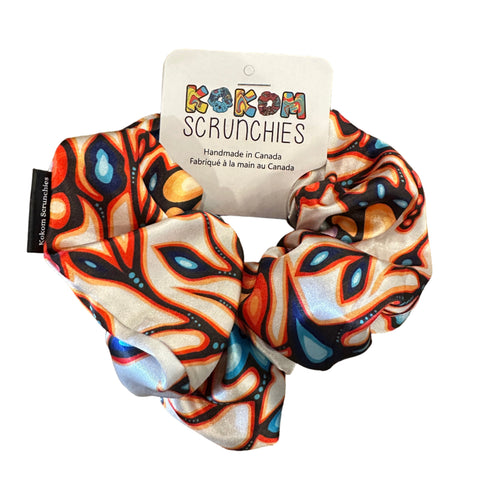 Colorful scrunchie with a brand tag on a wooden surface