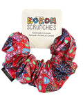 Colorful scrunchie with a brand tag on a wooden surface
