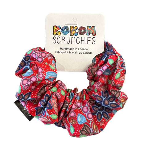 Colorful scrunchie with a brand tag on a wooden surface