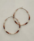Pair of beaded hoop earrings on a light gray background