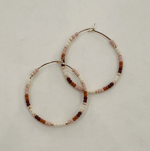 Pair of beaded hoop earrings on a light gray background