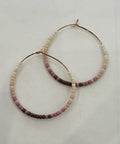 Pair of beaded hoop earrings on a light gray background