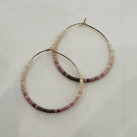 Pair of beaded hoop earrings on a light gray background