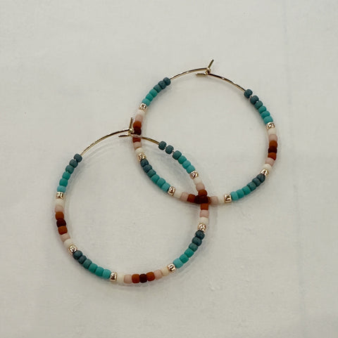 Set of beaded hoop earrings on a light gray background