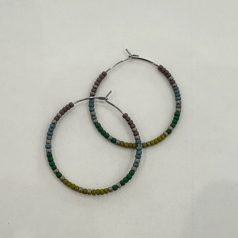 Pair of beaded hoop earrings on a light gray background