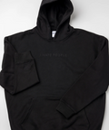 A black pullover hoodie with 'I HATE PEOPLE' printed in a subtle dark gray font on the chest, laid flat on a light gray background.