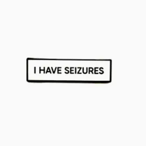 Black rectangular sign with 'I HAVE SEIZURES' text on a white background
