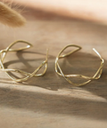 Gold earrings on a wooden surface