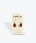 Pair of tiger eye teardrop earrings on a 'Dawna Olson' branded card against a white background