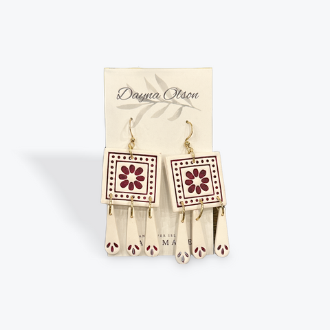 Pair of earrings with floral design on a beige card with 'Dayna Olson' branding.