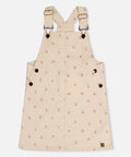 Deux par Deux beige corduroy overall dress with a prairie flower print and adjustable straps.