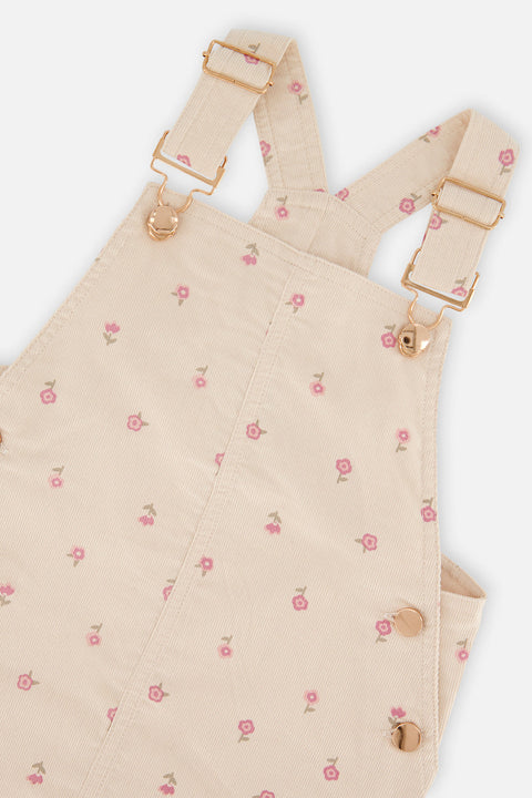 Close-up of the floral corduroy fabric, strap buckles and buttons on the Deux par Deux overall dress.